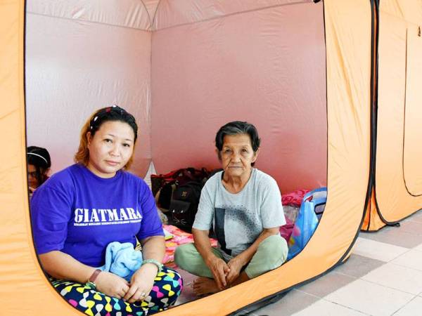 Samilin Malibin, 45, bersama ibunya, Norotiah Angilong, 71, (kanan) dari Kampung Kayai Membakut adalah antara mangsa banjir yang berpindah ke pusat pemindahan mangsa banjir di Beaufort hari ini. -FOTO: BERNAMA