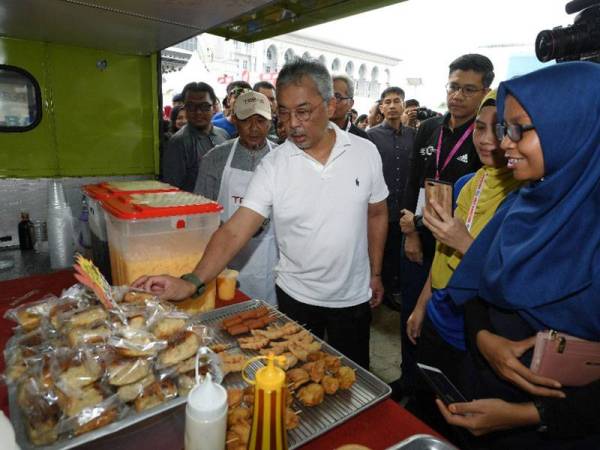 Yang di-Pertuan Agong (tengah) berkenan melawat gerai jualan makanan golongan asnaf ketika hadir ke Karnival Usahawan Koperasi Kementerian Pembangunan Usahawan 2019 dan Majlis Pengurniaan Hadiah 9 to 5 Run Half Marathon di Pekarangan Istana Kehakiman hari ini. - Foto Bernama