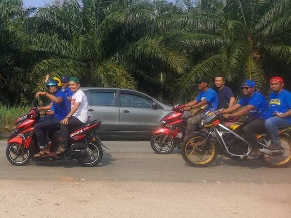 Khairy menunggang motosikal bersama penduduk di Serkat hari ini. - Foto: Sharifudin Abdul Rahim