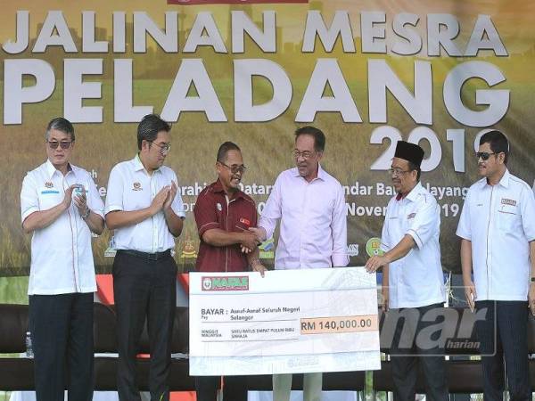 Pengerusi Pertubuhan Peladang Kawasan Klang, Muner Suandi (tiga dari kiri) menerima replika cek sumbangan wakalah zakat perniagaan Nafas bagi negeri Selangor daripada Anwar (tiga dari kanan) pada program Jalinan Mesra Peladang 2019 di Dataran Ilmu, Bandar Baru Selayang semalam.