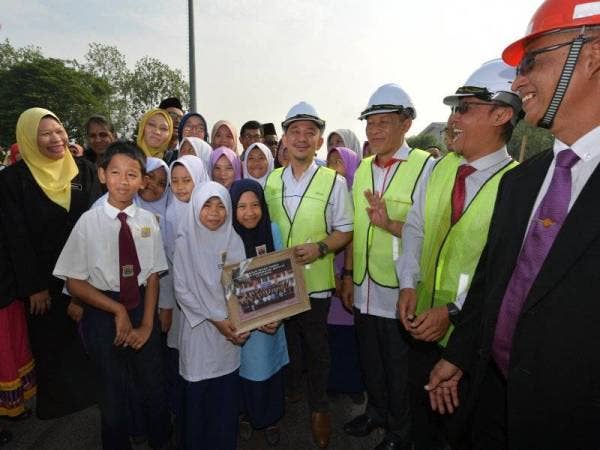 Menteri Pendidikan, yang juga Ahli Parlimen Simpang Renggam Dr Maszlee Malik, (empat, kanan) dan calon Pakatan Harapan bagi Pilihan Raya Kecil (PRK) Parlimen Tanjung Piai Karmaine Sardini (tiga, kanan) bergambar dengan murid-murid sekolah selepas melakukan simbolik Pecah Tanah Dewan Terbuka Sekolah Kebangsaan Batu 24, Pekan Nanas hari ini. - Foto Bernama