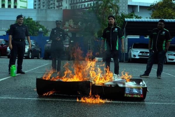 Sebahagian daripada poster dan gegantung iklan pinjaman wang tidak berlesen dan pinjaman tidak wujud yang dirampas sekitar pulau ini bermula semalam dibakar di pekarangan Ibu Pejabat Polis Daerah Langkawi hari ini. - Foto Bernama