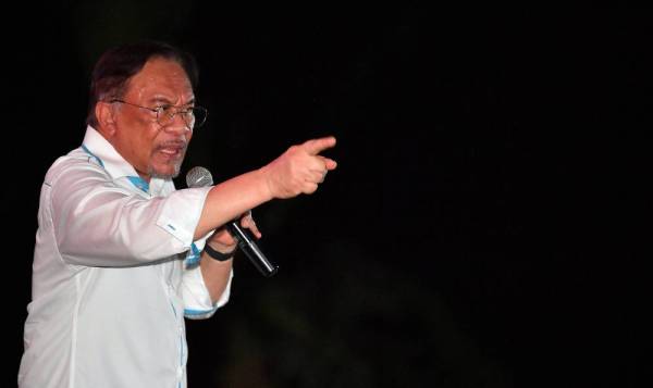 Anwar menyampaikan amanatnya ketika berkempen bagi PRK Parlimen Tanjung Piai di Taman Utama Pekan Nanas malam ini. - Foto Bernama