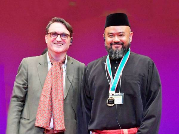 Irwan (kanan) bersama salah seorang juri Digicon 6 Asia, Professor Richard William Allen yang memuji BatikGirl sebagai sebuah filem pendek animasi fantasi indah yang ditonjolkan melalui reka bentuk karakter dan mainan warna yang harmoni serta imaginasi yang kreatif.