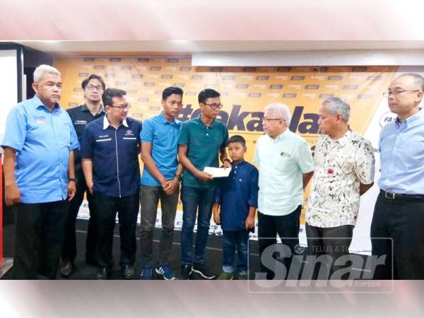 Mohd Zahim Muhaimin (tengah) ketika menerima sumbangan khas daripada Hussamuddin (tiga dari kanan).