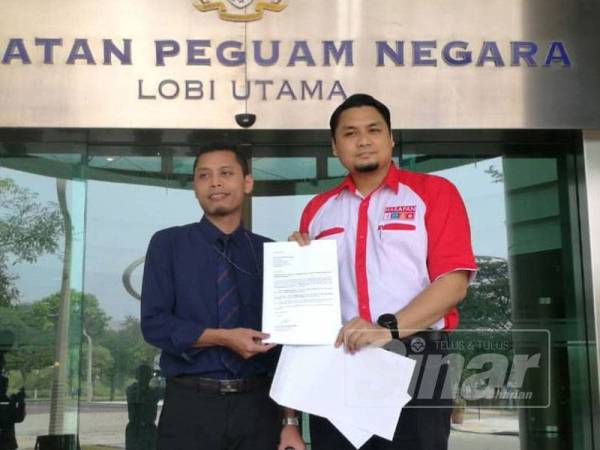 Dr Faiz (kiri) menyerahkan memorandum kepada pegawai AGC sebentar tadi.