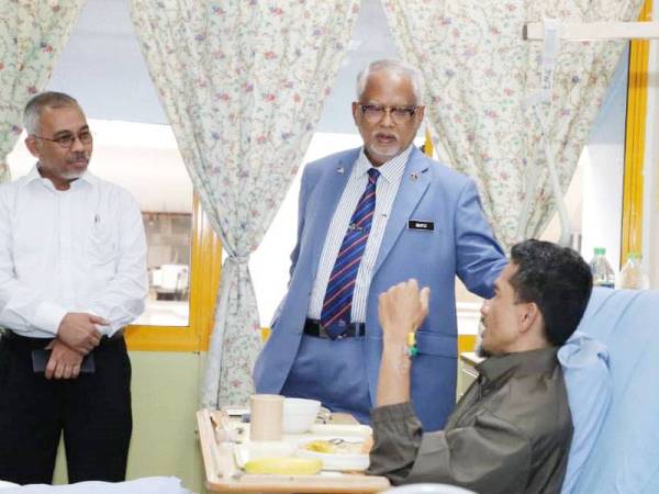 Mahfuz (tengah) bertanya sesuatu ketika menziarahi Ahmad Taufik di Hospital Kuala Lumpur, semalam.