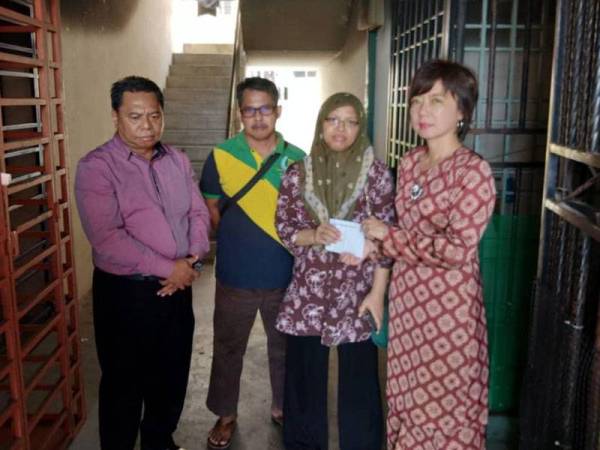 Nicole menyampaikan sumbangan kepada keluarga berkenaan.