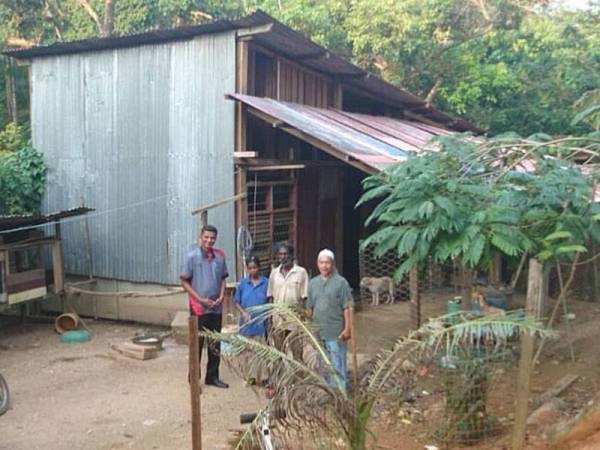 Pegawai Kebajikan DUN Taboh Naning, Taufiq Abd Rahma (kiri) bersama Setiausaha Majlis Perwakilan Komuniti Kampung Brisu, Daud Sharif ketika melawat pasangan suami isteri itu.