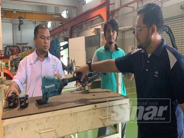 Mohd Rizal (kiri) menunjukkan cara-cara pemasangan Cantas Elektro yang lebih mudah dan menjimatkan masa.