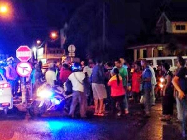 Orang ramai yang berada di tempat kejadian membantu mangsa yang ditikam seorang lelaki di Jalan Tunku Asaad, Kulim malam tadi.