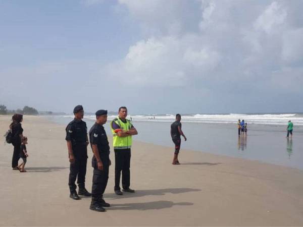 Mohd Zain (kanan) bersama dua anggotanya turun padang meninjau aktiviti pengunjung mengutip kerang bulu di Pulau Kekabu, di sini.