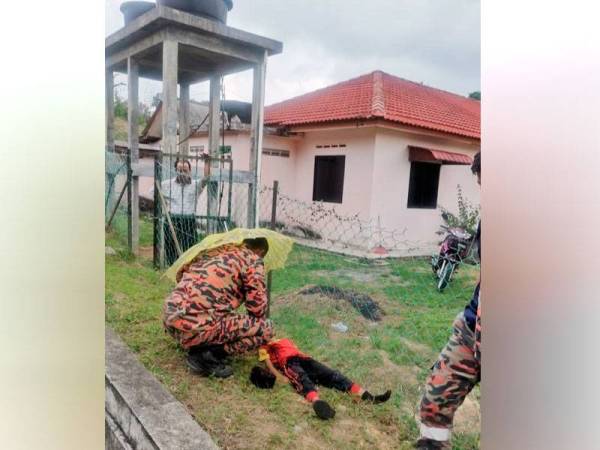 Anggota bomba sedang memeriksa keadaan mangsa yang cedera digigit anjing. Foto: Ihsan PDRM