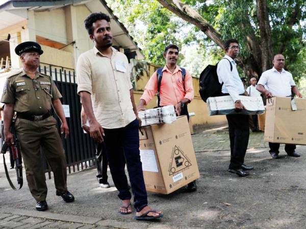 Pegawai pilihan raya membawa bahan kelengkapan untuk ke pusat mengundi semalam. Berjuta pengundi berdaftar di Sri Lanka akan membuat pilihan presiden mereka hari ini. - Foto Agensi