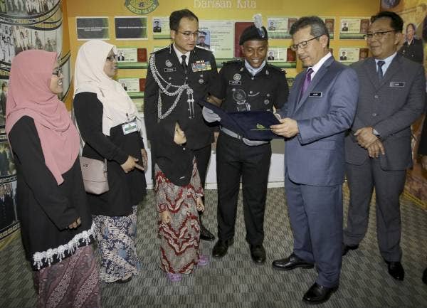 Alwi (dua dari kanan) beramah mesra dengan Penerima Kadet Terbaik Anugerah Ketua Pengarah Imigresen, Amirul Fauzan Hassan Zaim (empat dari kiri) pada Majlis Perbarisan Tamat Latihan Kursus Asas Pegawai Imigresen Gred KP 19 Siri 3 2019 di Akademi Imigresen Malaysia hari ini. -Foto Bernama