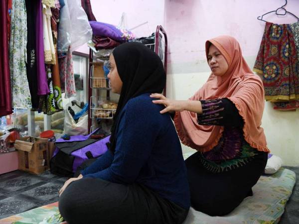 Malikah Cholil, 38, ibu tunggal cacat penglihatan membanting tulang empat keratnya dengan melakukan empat jenis kerja demi kelangsungan hidup. Dia terpaksa melakukan empat jenis kerja iaitu mengurut, mendobi, mengambil upah membungkus 'bola tikam' dari sebuah kilang tempatan dan menjual produk-produk dari Indonesia di rumahnya yang terletak di Flat Taman Kota Permai. Beliau gembira kerana dapat menjana pendapatan menggunakan kudrat sendiri walau hanya memperoleh sekitar RM400 setiap bulan. - Foto Bernama