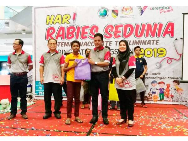 Datuk Dr Quaza Nizamuddin menyampaikan hadiah kepada pemenang pertandingan mewarna.