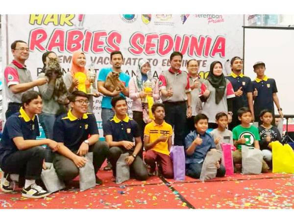 Dr Quaza Nizamuddin (tengah) bersama pemenang pertandingan mewarna dan kucing tercantik yang dianjurkan sempena Hari Rabies Sedunia semalam.