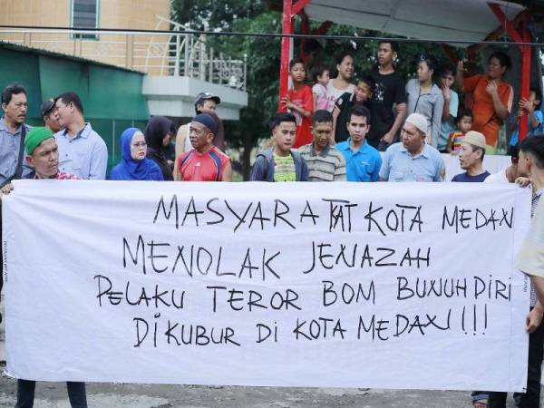 Penduduk di Medan semalam membantah pengebom bunuh diri dikebumikan di bandar itu. - Foto AFP