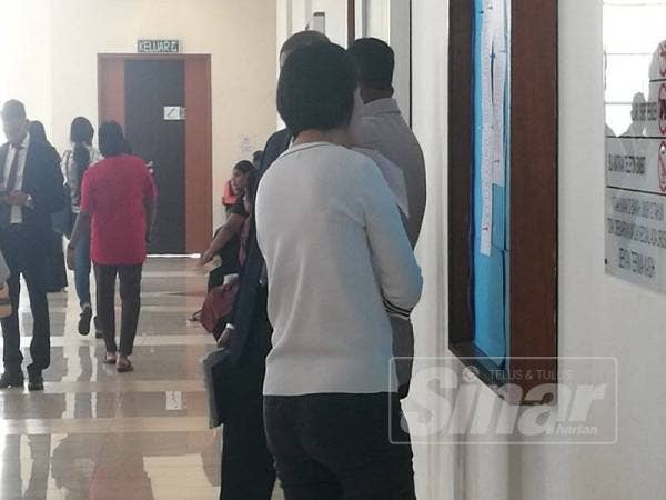 Tertuduh cuba mengelak apabila gambarnya cuba dirakam lensa kamera wartawan.