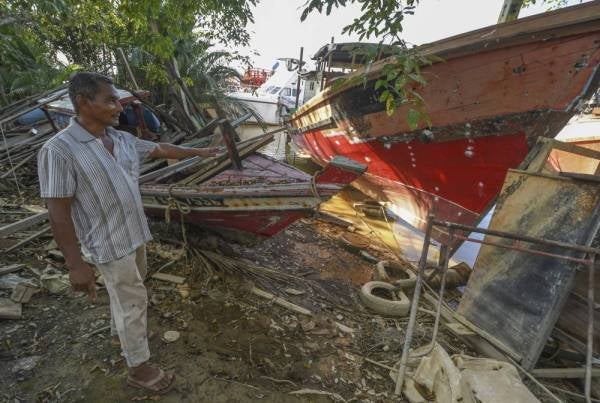 Ismail Hussin, 50, menunjukkan sebahagian bot nelayan yang akan dibaiki ketika ditemui di Teluk Buaya, Pantai Mek Mas hari ini.--Foto Bernama
