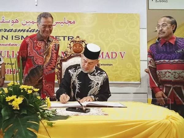 Sultan Muhammad V berkenan menandatangani buku tetamu.