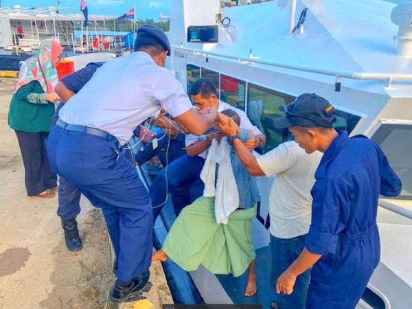 Anggota APMM Kelantan membantu pesakit sebelum dibawa ke klinik. - Foto: APMM Kelantan