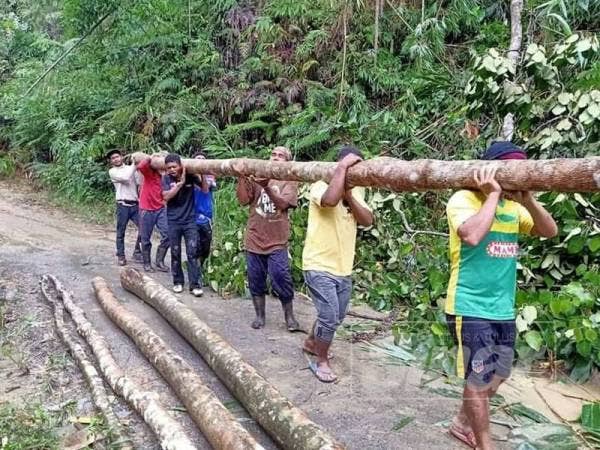 Guru-guru dan penduduk orang asli bersama dalam membaiki laluan rosak.
