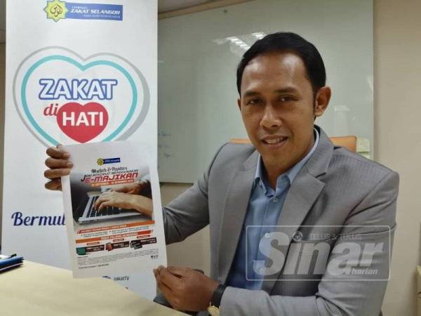 Mohd Sabirin menunjukkan risalah berkenaan E-Majikan yang disediakan LZS.