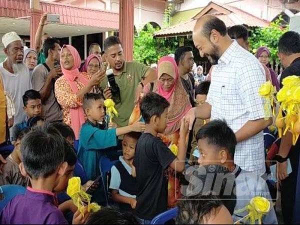 Mukhriz (kanan) menyampaikan sumbangan kepada kanak-kanak yang menyertai program berkhatan beramai-ramai bersama Tok Mudim di Masjid Bani Hashim Hosba di sini hari ini.