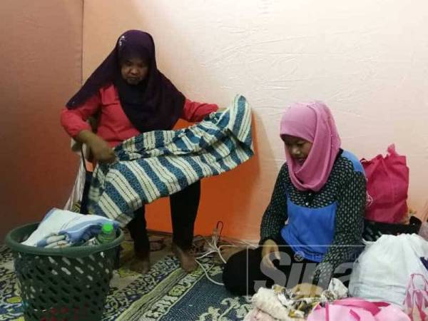 Sulaini (kiri) dan ahli keluarganya kini ditempatkan di pusat pemindahan sementara di Dewan Sivik Wakaf Tapai.
