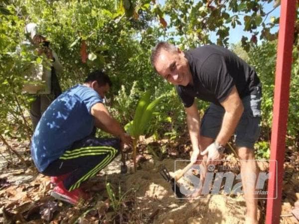 Sheikh Muszaphar (kiri) dan Anton Nikolaevich Shkaplerov (kanan) menanam pokok kelapa di tepi pantai.