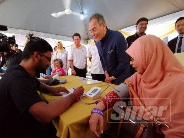 Dr Dzulkefly melihat dengan lebih dekat hasil bacaan tekanan darah seorang wanita pada program Mamogram Percuma Etiqa Fasa Tiga di Bangunan NCSM hari ini.