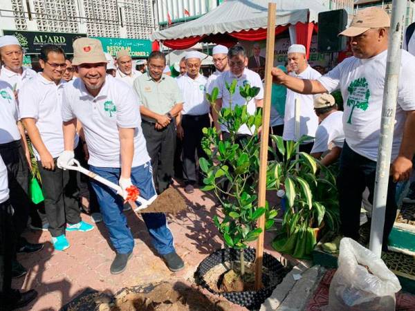 Dr Izani menanam pokok di tepi laluan Medan Ilmu sebagai gimik perasmian program Go Green.