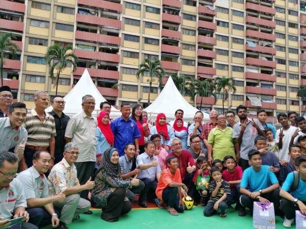 Khalid bergambar bersama penduduk Sri Sarawak pada program Inisiatif Wilayah Peduli di sini hari ini.