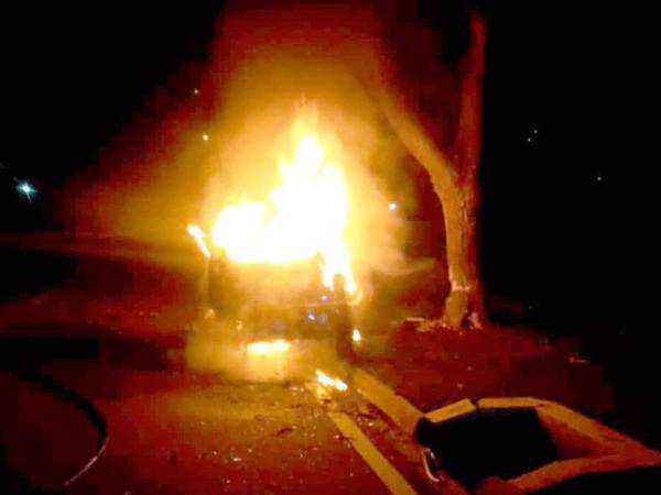 Kereta mangsa dipercayai hilang kawalan lalu terbabas melanggar sebatang pokok yang berada di tengah pembahagi jalan sebelum terbakar.