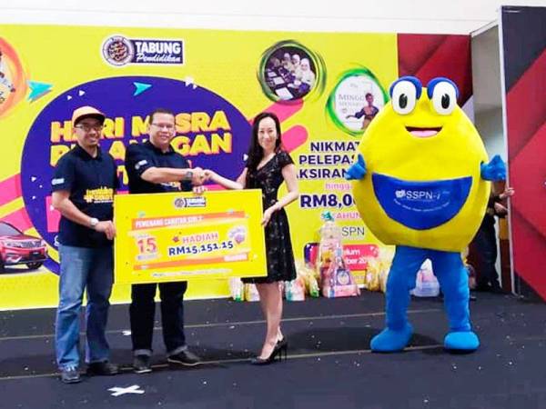 Abdul Ghaffar (dua dari kiri) menyampaikan replika cek untuk cabutan hadiah kepada Hsie Yse sempana Hari Mesra Pelanggan PTPTN di UTC Galeria@Kotaraya di Johor Bahru, kelmarin.