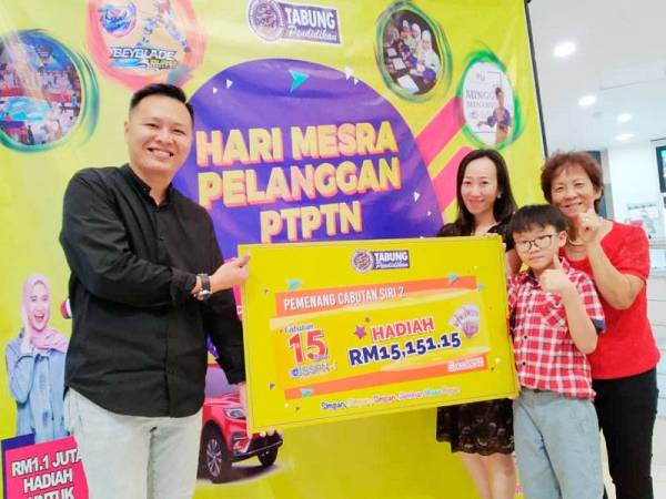 Hsie Yee (dua dari kiri) bersama suami bergambar bersama replika cek yang dimenangi pada Hari Mesra Pelanggan PTPTN di UTC Galeria @ Kotaraya, Johor Bahru kelmarin.