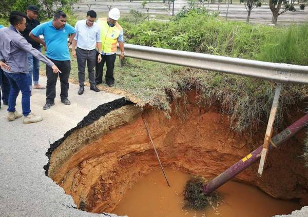 Chean Chung (dua dari kanan) bersama wakil agensi berkaitan meninjau lokasi berlaku hakisan tanah di Bypass Semambu hari ini.