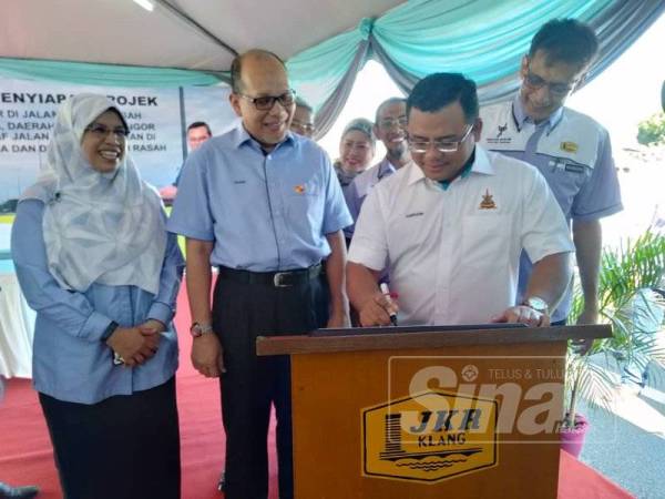 Amirudin menurunkan tandatangan sebagai simbolik pelancaran projek tebatan banjir di Jalan Sungai Rasah hari ini.