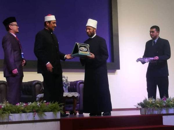 Syed Ibrahim (dua dari kiri) menyampaikan cenderamata kepada Usamah Sayyid Mahmud