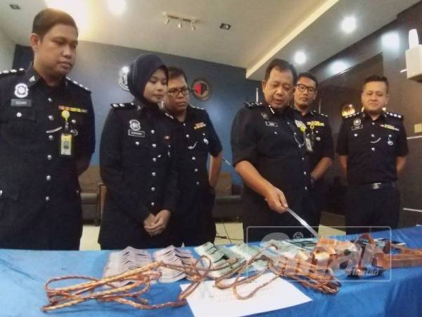 Zainol menunjukkan barangan yang dirampas daripada suspek.