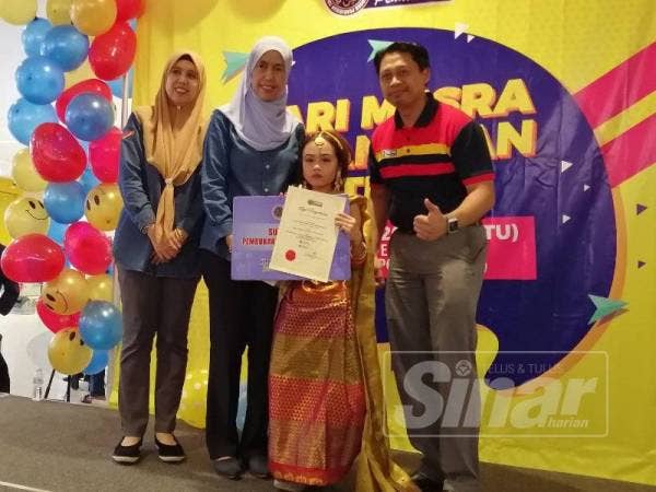 Mastura (dua dari kiri) menyampaikan hadiah kepada seorang peserta cilik yang menyertai aktiviti pada Hari Mesra Pelanggan PTPTN 2019 di Sunway Velocity Mall Cheras Sabtu lalu.