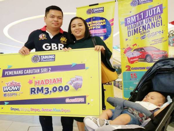 Andy, isteri dan anaknya bersama replika cek RM3,000 yang dimenangi dalam Cabutan WOW! SSPN-i Plus.