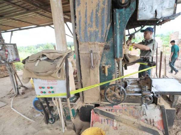 Penguat kuasa JPNP ketika menyita mesin di kilang papan haram yang beroperasi di Batu 12 Jalan Kuantan - Gambang pada hari pertama Operasi Bersepadu Ops Kilang kelmarin