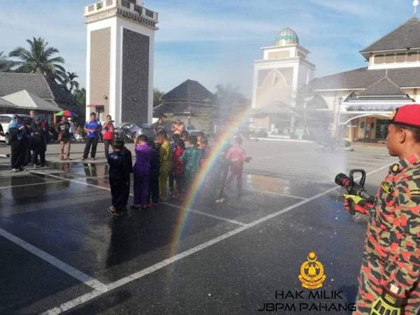 Anggota bomba memandikan peserta khatan di Masjid Felda Sungai Koyan 1, semalam.