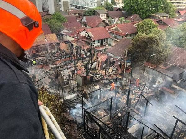 Anggota bomba melakukan kerja-kerja memadamkan kebakaran yang berlaku di kampung berhampiran Taman Cemerlang, Jelutong pagi tadi. - Foto Jabatan Bomba dan Penyelamat Malaysia