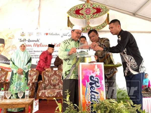 Md Anizam (kiri) menyempurnakan gimik perasmian pra pelancaran TMK 2020 di Dataran Rehal hari ini.