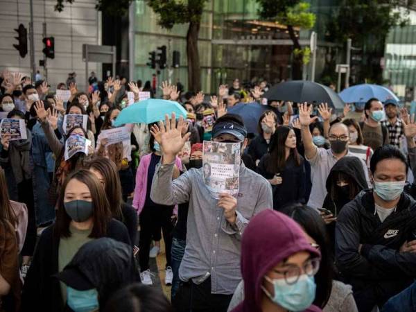 Penunjuk perasaan prodemokrasi berkumpul ketika waktu rehat makan tengah hari di bandar Kwun Tong semalam. - Foto AFP