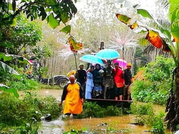 Pasangan raja sehari, Mohd Abdul Rozaid dan Nor Afiqah diarak menggunakan backhoe sambil diiringi traktor serta lori ekoran hujan lebat.